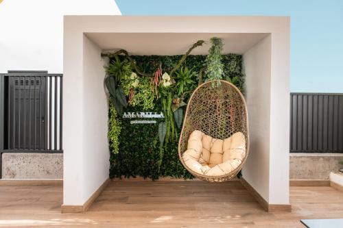 a wicker chair in front of a green wall at Amarilla Golf Residences in San Miguel de Abona