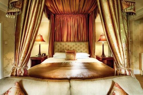 a bedroom with a canopy bed with two lamps at Mansion House Hotel in Elgin
