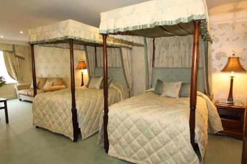 two twin beds in a bedroom with two lamps at Mansion House Hotel in Elgin