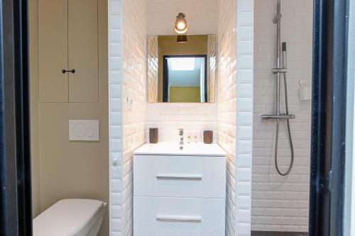 La salle de bains est pourvue d'un lavabo blanc et d'une douche. dans l'établissement Superbe maison au coeur de la ville à deux pas de la Côte des Basques, à Biarritz