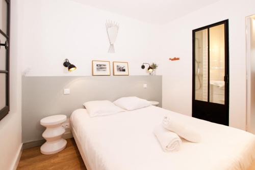 ein weißes Schlafzimmer mit einem Bett und einem WC in der Unterkunft Superbe maison au coeur de la ville à deux pas de la Côte des Basques in Biarritz