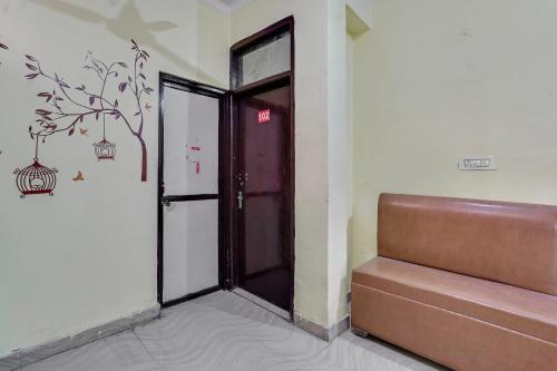 wejście do budynku z drzwiami i ławką w obiekcie Flagship Baba Guest House w mieście Indirapuram