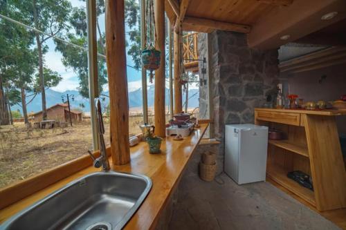 uma cozinha com um lavatório e uma grande janela em Cabaña Maras Peru em Maras