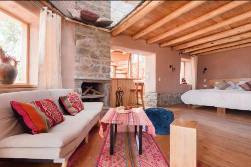 uma sala de estar com um sofá e uma lareira em Cabaña Maras Peru em Maras