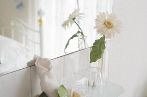 a vase with flowers sitting on a counter next to a window at Maison Dieu Guest House in Dover