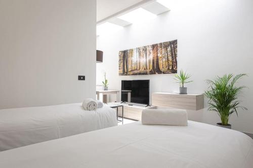 a white room with two beds and a fireplace at Melissa Suite in Casalecchio di Reno