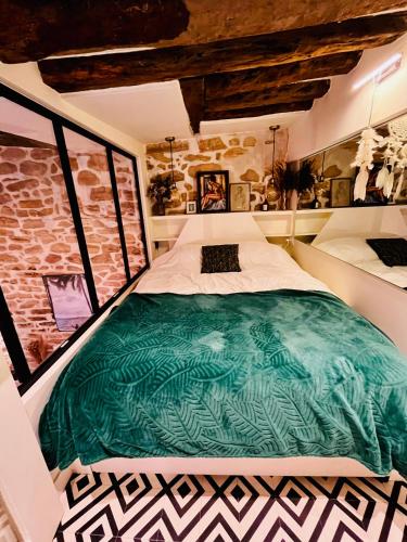 - une chambre avec un grand lit vert dans l'établissement Plein cœur de Paris : Charmant Duplex à Bastille, à Paris