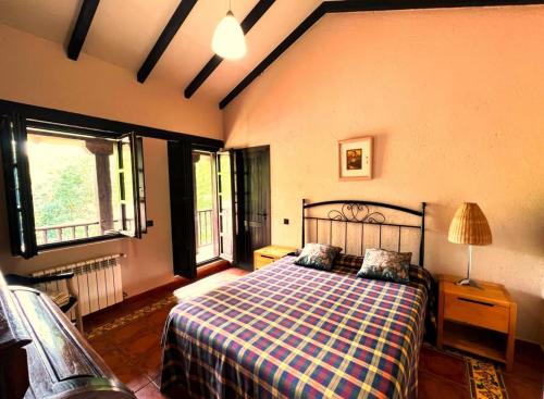 um quarto com uma cama com um cobertor xadrez em Casa Rural El Pozo Tremeo em Soña