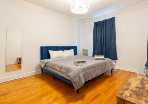 a bedroom with a bed with a blue headboard at Designer Three Bd Apartment In NYC in New York