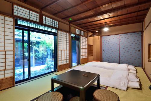 1 dormitorio con 1 cama, mesa y sillas en Takeya Kitano Honkan, en Kioto