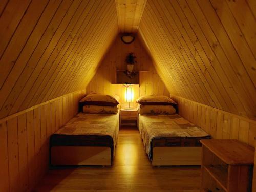 a room with two beds in a wooden room at uMarcina in Jurgów