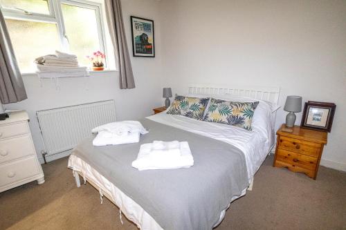 1 dormitorio con 1 cama con toallas en No. 2 Watch House en Dawlish