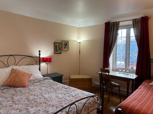 a bedroom with a bed and a desk and a window at À l'Adresse du Centre-Ville in Montreal