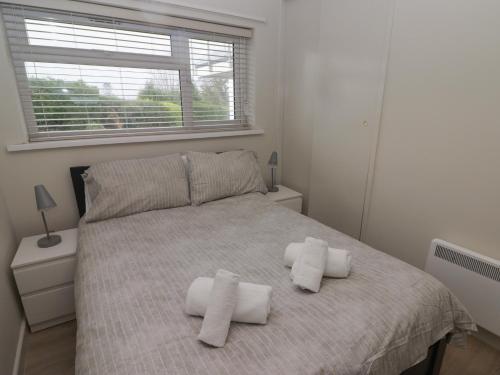 una camera da letto con un letto e asciugamani di 21 Coedrath Park a Saundersfoot