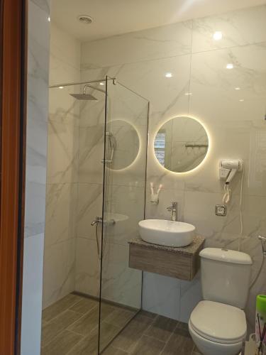 een badkamer met een douche, een toilet en een wastafel bij Посуточный гостевой дом in Gjoemri