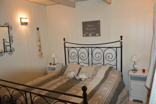 Dois ursos de peluche sentados numa cama num quarto em Le Chalet De Papitou em Hockai