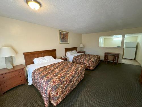 a hotel room with two beds and a table at Big Chile Inn & Suites in Las Cruces