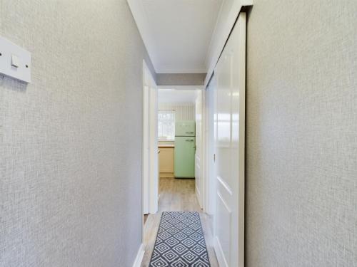 a hallway leading to a kitchen with a green refrigerator at Exquisite Bungalow in Hessle