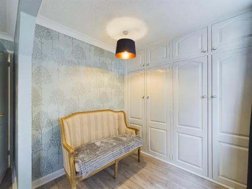 a room with a chair and a wall at Exquisite Bungalow in Hessle