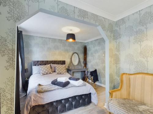 um quarto com uma cama grande num quarto com papel de parede em Exquisite Bungalow em Hessle