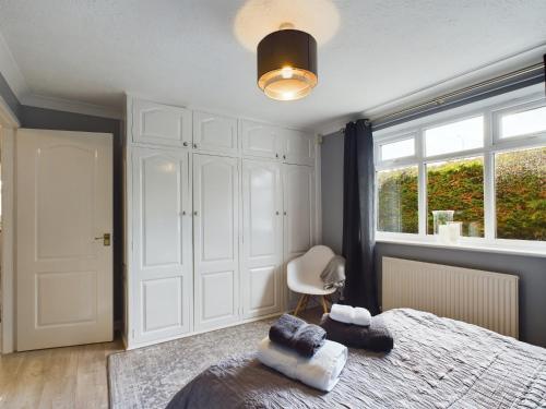a bedroom with a bed and a chair and a window at Exquisite Bungalow in Hessle