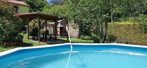 a swimming pool with a water fountain at Paraíso Ortegal in Feás