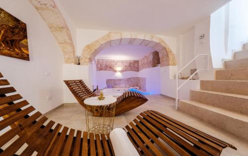 a room with a table and chairs and stairs at Il Pumo Bianco Ostuni Suite in Ostuni