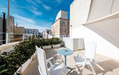 a patio with chairs and a table on a balcony at Il Pumo Bianco Ostuni Suite in Ostuni