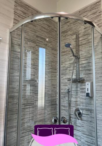 a bathroom with a shower with a pink bed at B&B ANASTASIA in Pompei