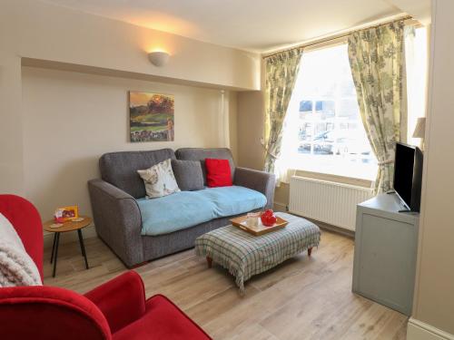 a living room with a couch and a tv at 8 Market Place in Ripon