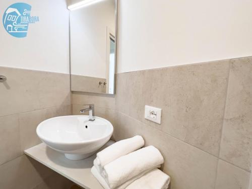 La salle de bains est pourvue d'un lavabo, d'un miroir et de serviettes. dans l'établissement Slataper 12 Tirabora Short Rent, à Trieste
