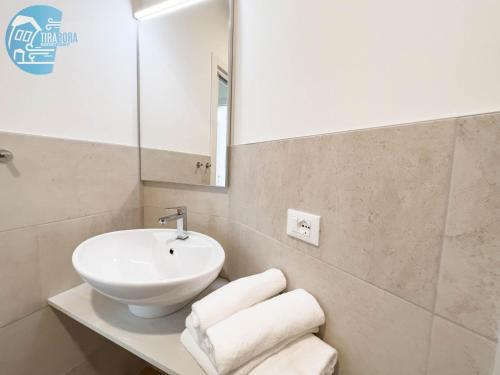 Un baño con lavabo, espejo y toallas. en Slataper 12 Tirabora Short Rent, en Trieste