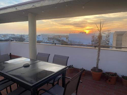 un tavolo e sedie su un balcone con vista sul tramonto di DUPLEX JUNTO al RECINTO FERIAL y PUENTE ROMANO con GRAN TERRAZA y PARKING PRIVADO a Cordoba