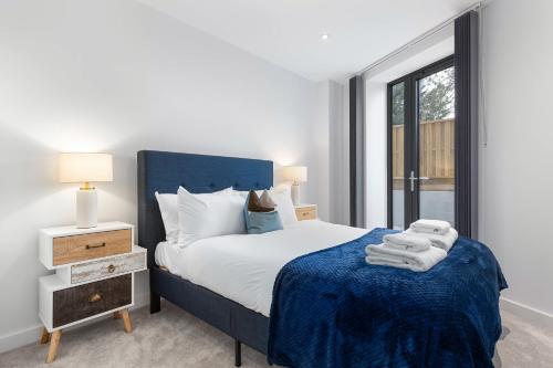 a bedroom with a blue bed and a window at SERCASA - Wembley Park - London in Preston