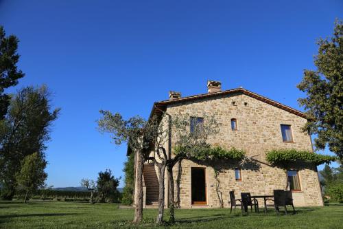 an old stone building with a table and chairs at Valle di Assisi Country Apartments in Assisi
