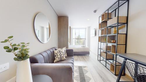 a living room with a couch and a mirror at The Cabrera Eighty Fifth Hotel in Bogotá