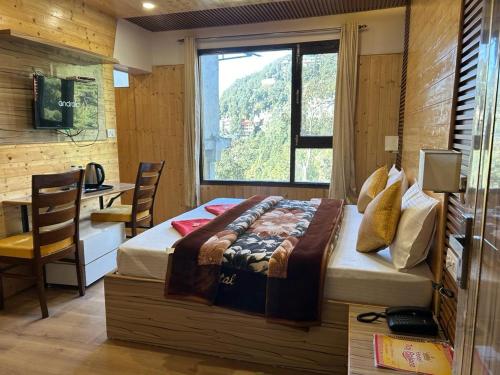 Schlafzimmer mit einem Bett, einem Schreibtisch und einem Fenster in der Unterkunft HOTEL MA HEIGHTS in Dalhousie