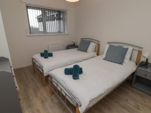 2 camas con almohadas azules en una habitación en 19 Coedrath Park en Saundersfoot