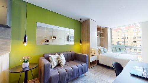 a living room with a couch and a bedroom at The Cabrera Eighty Fifth Hotel in Bogotá