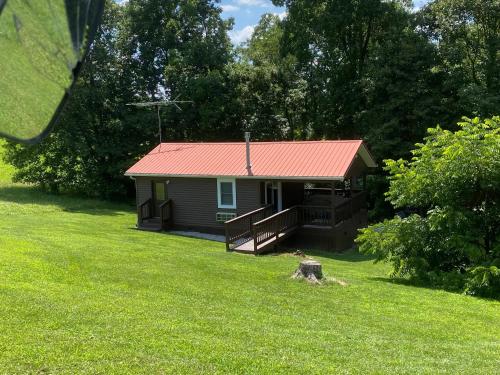 a small cabin with a red roof in a yard at The Mockingbird in Logan