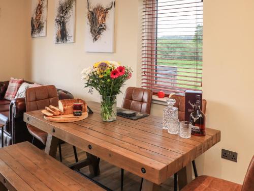 a wooden table with a vase of flowers on it at Pine Marten in Dornoch