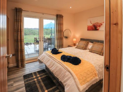 a bedroom with a bed with two bags on it at Pine Marten in Dornoch