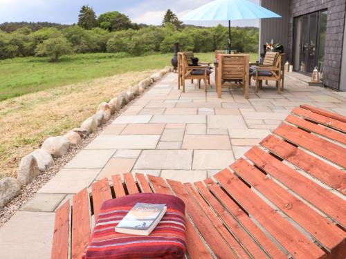 a bench with a book on it next to a patio at Pine Marten in Dornoch