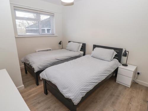 two twin beds in a room with a window at 36 Coedrath Park in Saundersfoot