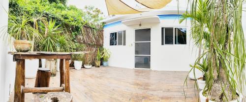 a house with a porch with potted plants at Aljanna House in Bacalar