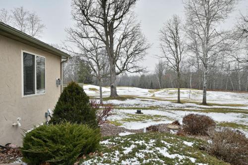 a house with snow on the ground next to a yard at Unit 701 5 bd 3 ba condo in Birchwood