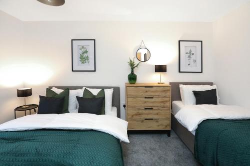 two beds in a bedroom with green and white at Beautiful House in Nottingham w/ Parking & WiFi - Sleeps 10 by PureStay Short Lets in Nottingham