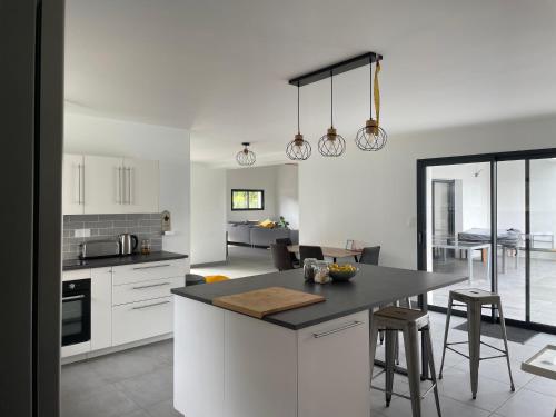 a kitchen with white cabinets and a black counter top at Villa de Groupe avec Piscine, Jacuzzi et Vue Nature in Pierric