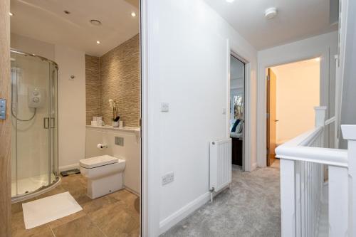 a bathroom with a toilet and a shower at Modern 4 Bed Home with Free Parking & Garden in Manchester