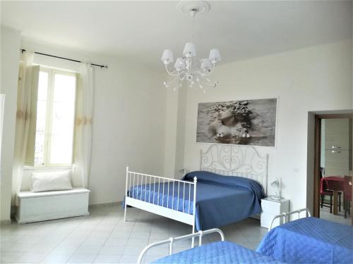 a bedroom with a blue bed and a chandelier at La Dimora delle Divinità in Naples